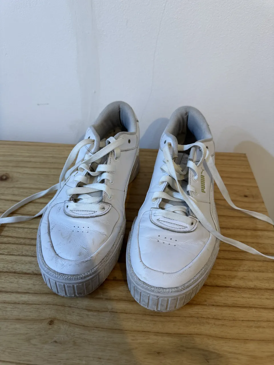 Zapatillas deportivas blancas de cuero con cordones. 