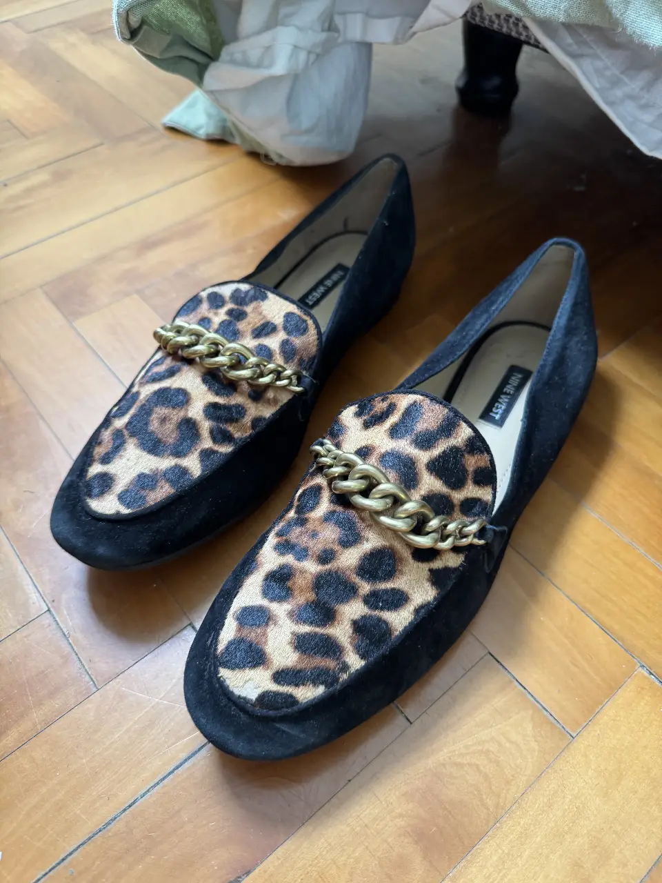 Mocasines Nine West de mujer, con diseño de animal print en la parte superior y detalle de cadena dorada. Talle 9.5M. Ideales para un look casual y elegante.