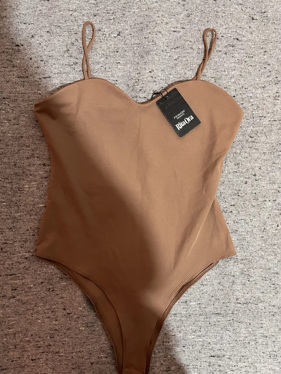 Body color nude de la colección Primark x Rita Ora, nuevo con etiqueta. Diseño elegante con tiras finas y copas que realzan la figura. Tela suave y cómoda, ideal para usar solo o combinar con pantalones o faldas.
📌 Nuevo con etiqueta
