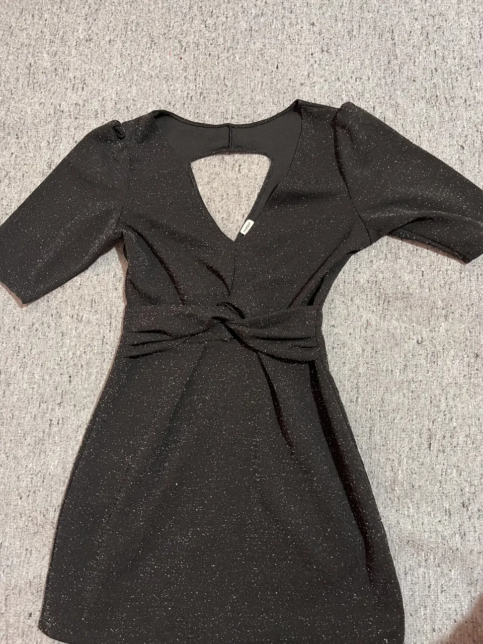 Vestido negro con brillos plateados. Escote en V con recorte triangular en la espalda. Mangas cortas con hombros fruncidos. Cintura con detalle de nudo.
📌 Excelente estado 
📌 2 usos