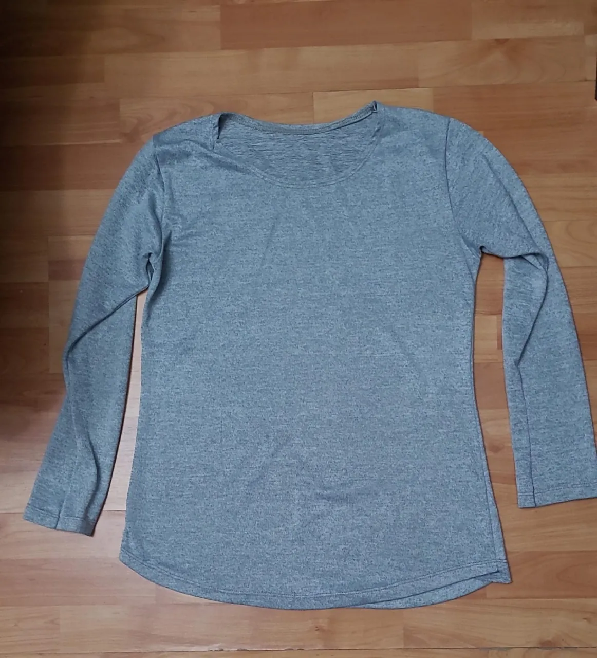 Remera de manga larga para mujer, de color gris. Ideal para usar en el día a día o para actividades deportivas.