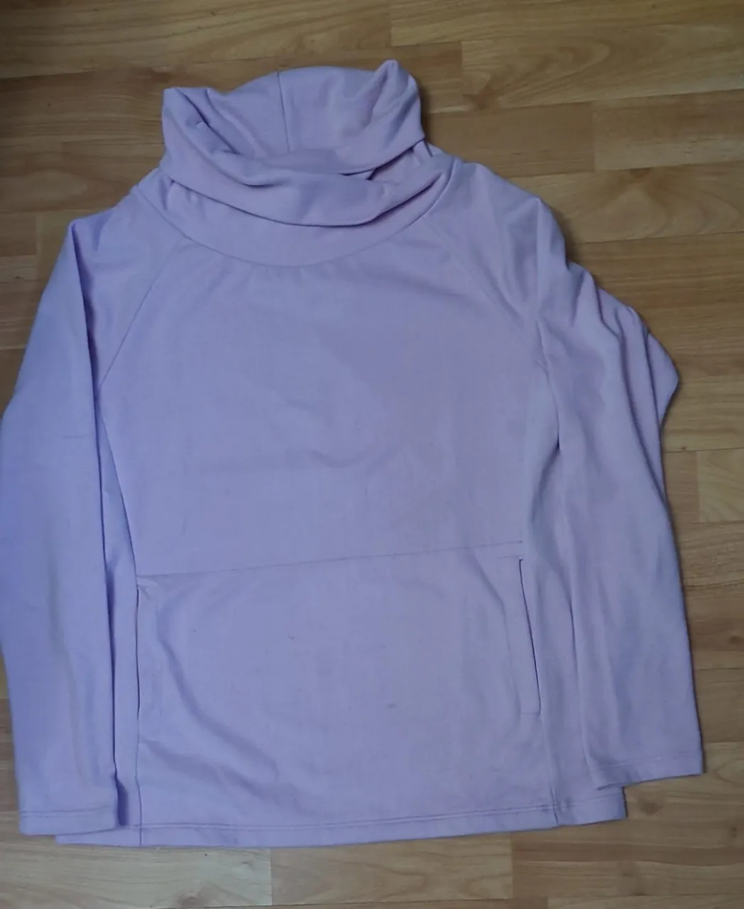Buzo polera de mujer, color lila claro. Cuello alto y bolsillo frontal. Ideal para un look casual y abrigado.