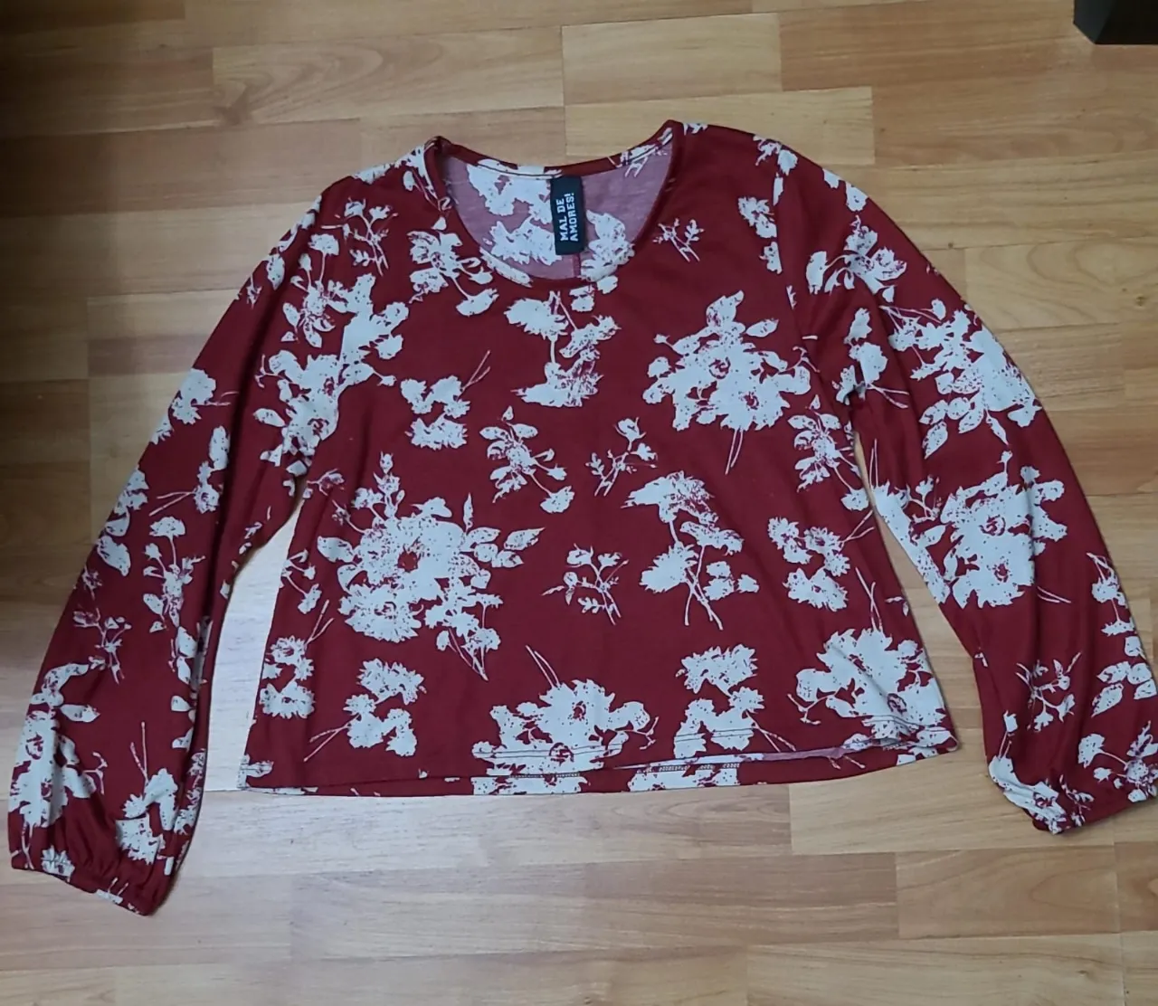 Blusa de manga larga para mujer, con estampado floral en tonos rojo y blanco. Ideal para un look casual y femenino.