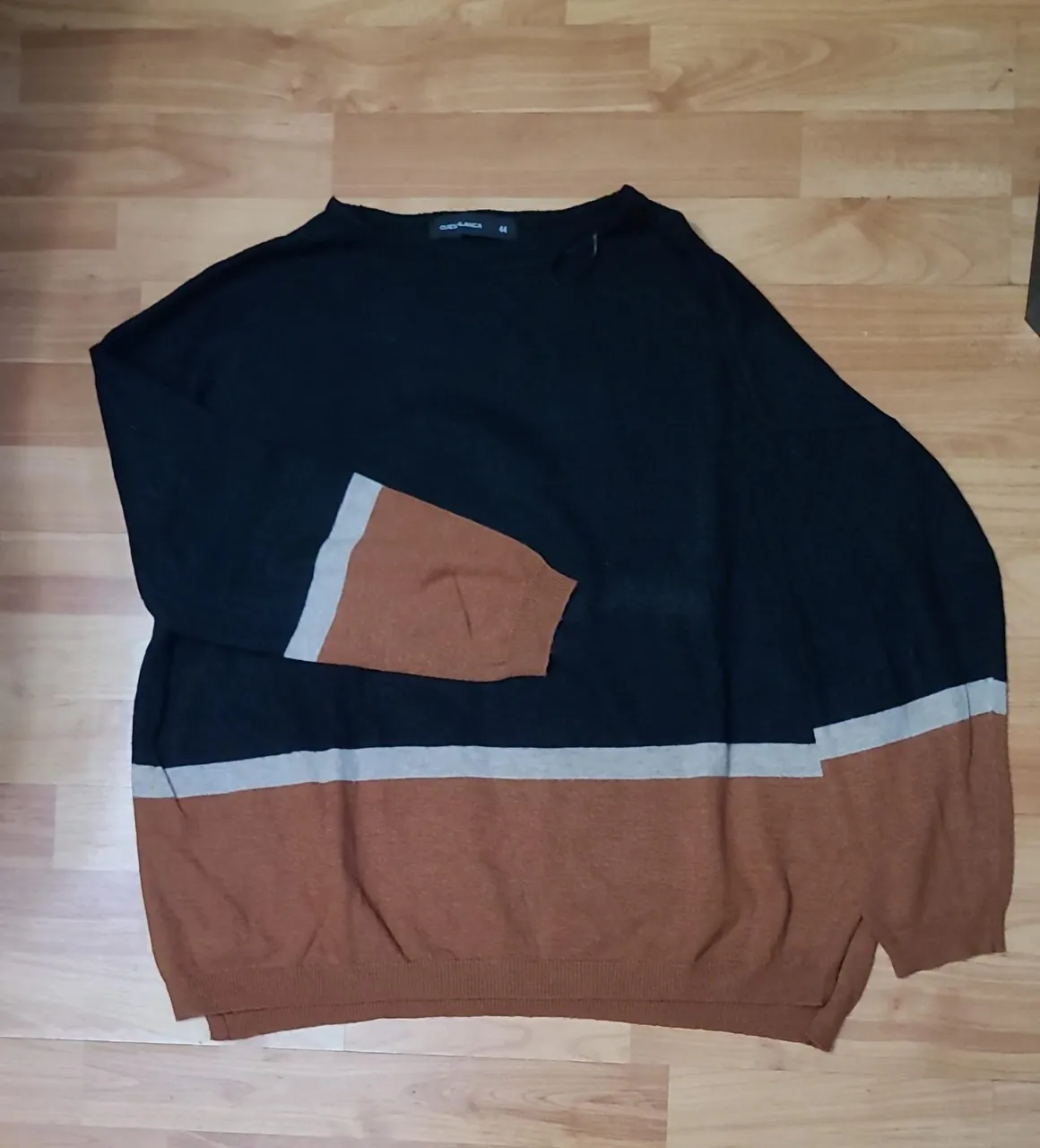 Sweater largo de mujer, con diseño en bloques de color negro y marrón. Cuello redondo y mangas largas. Ideal para un look casual y abrigado.