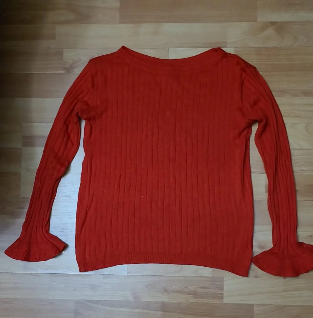 Sweater rojo de mujer, tejido con mangas largas acampanadas. Ideal para un look casual y moderno.