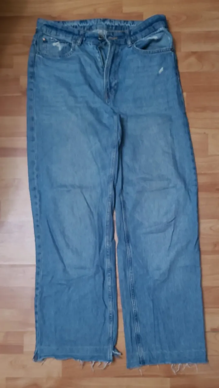 Jeans de mujer, tiro alto, corte recto, color azul claro, con detalles de roturas en la parte trasera. Talle 40 EUR, equivalente a un talle 8 US.