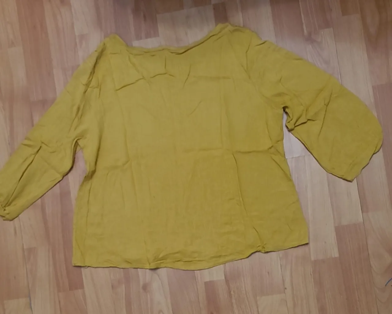Blusa de manga larga en color amarillo mostaza, ideal para un look casual y cómodo. Confeccionada en tela suave y fluida, perfecta para combinar con jeans o pantalones.