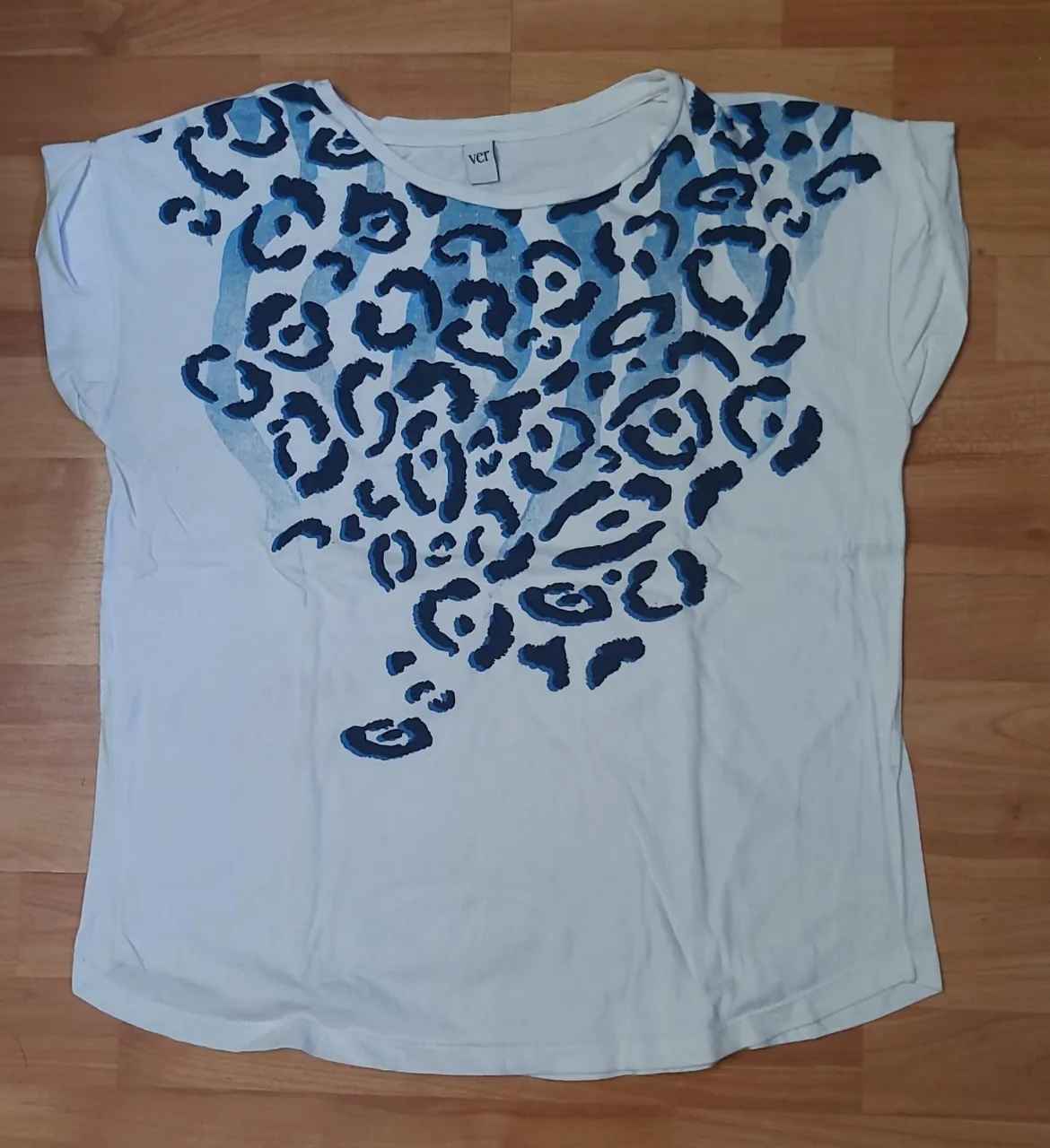Remera blanca de mujer con estampado de manchas azules. Cuello redondo y mangas cortas. Talle XS.