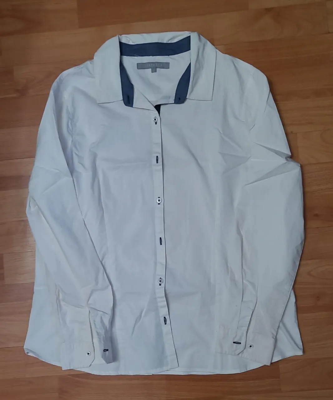 Camisa blanca de mujer con detalles en azul en el cuello. Marca Viaressa, ideal para un look casual o de trabajo.