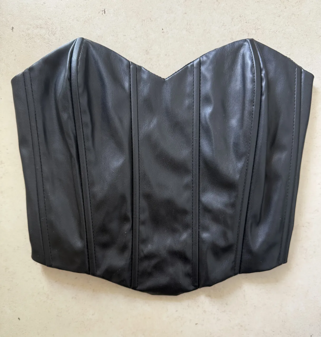 corset de cuero sintético negro. Diseño ajustado con ballenas y cordones en la espalda para un calce perfecto. 