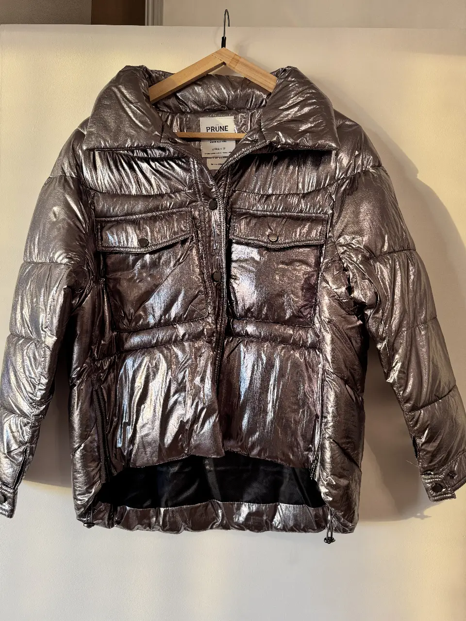Campera puffer PRÜNE metalizada plateada, con bolsillos y cierre. Ideal para el invierno.