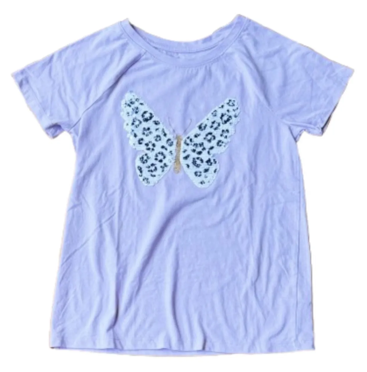 Remera de algodón color lila con un aplique de mariposa con lentejuelas y estampa animal print. Ideal para el día a día. Talle 10/12