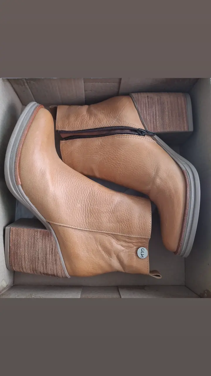 Botines de cuero color marrón claro con taco de madera. Diseño moderno y elegante, ideales para complementar cualquier look.