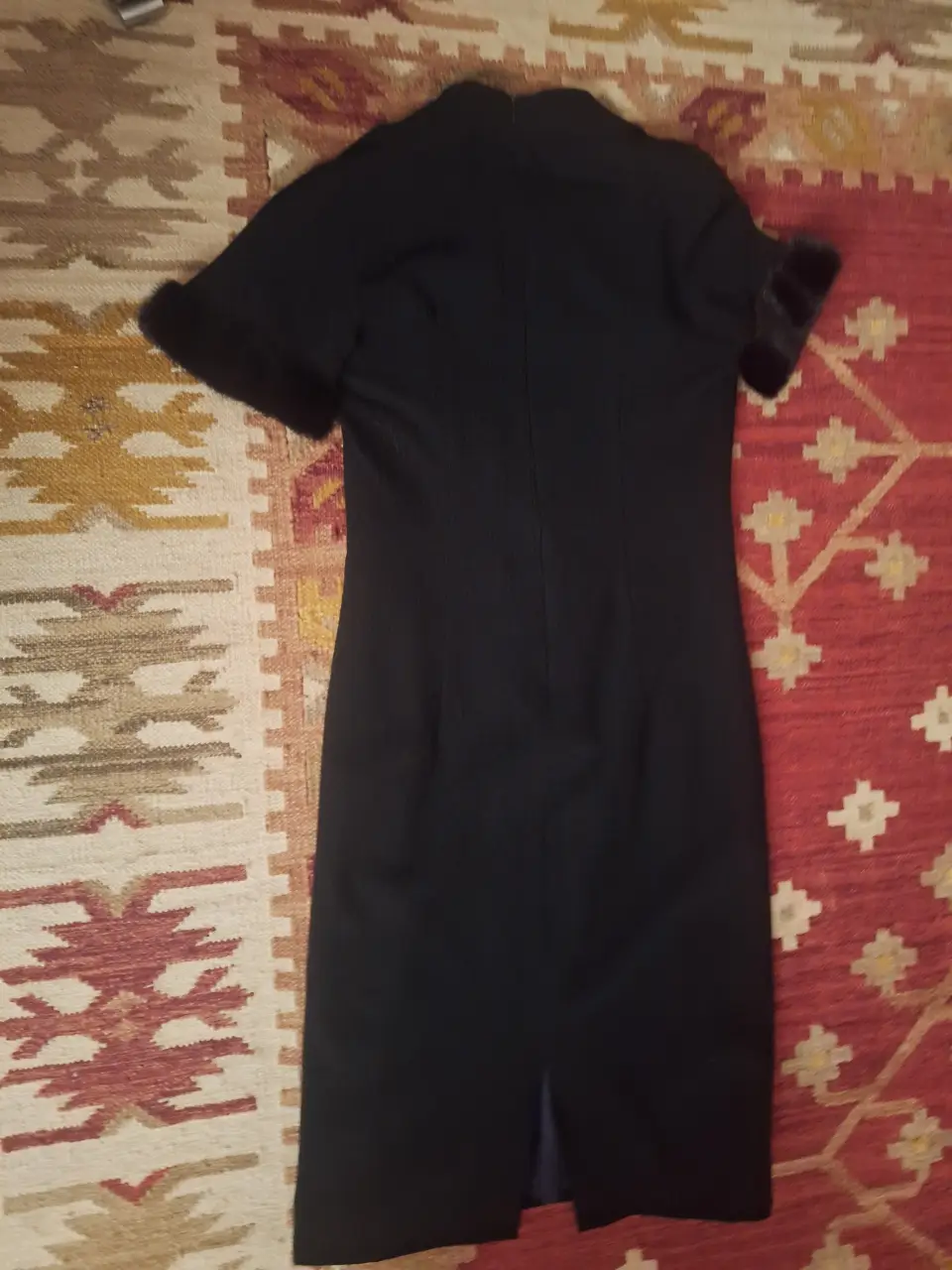 Vestido midi negro con mangas cortas y detalles de piel en los puños. Ideal para eventos formales o de trabajo.