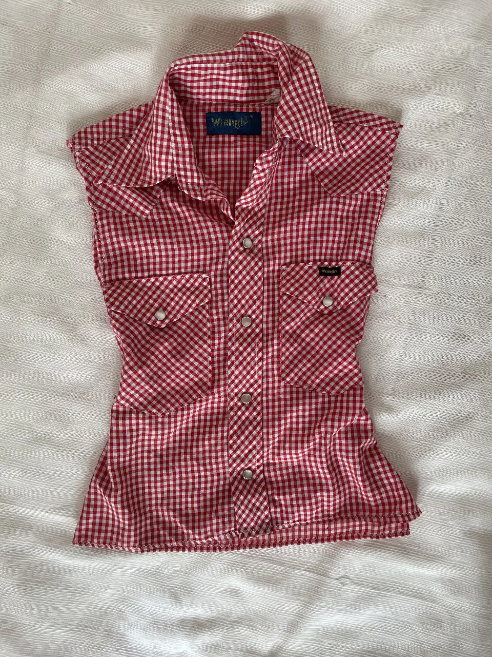 Camisa sin mangas de mujer, estilo western, con estampado a cuadros rojos y blancos. Cuenta con dos bolsillos delanteros y botones plateados. Ideal para un look casual y con onda.Vintage 