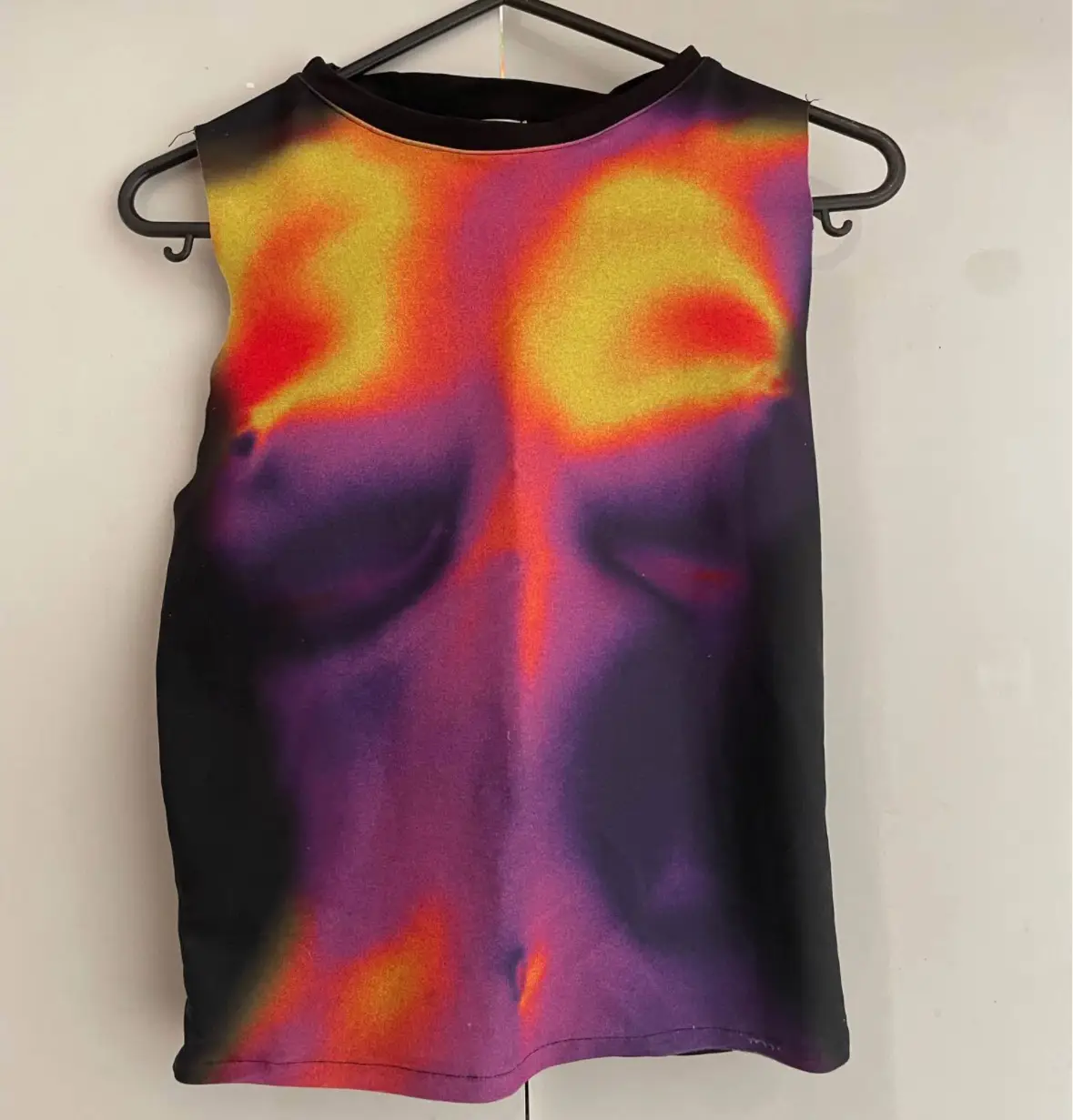 Musculosa con estampado abstracto en tonos cálidos y oscuros. Ideal para un look moderno y audaz.Tela que se ajusta al cuerpo 