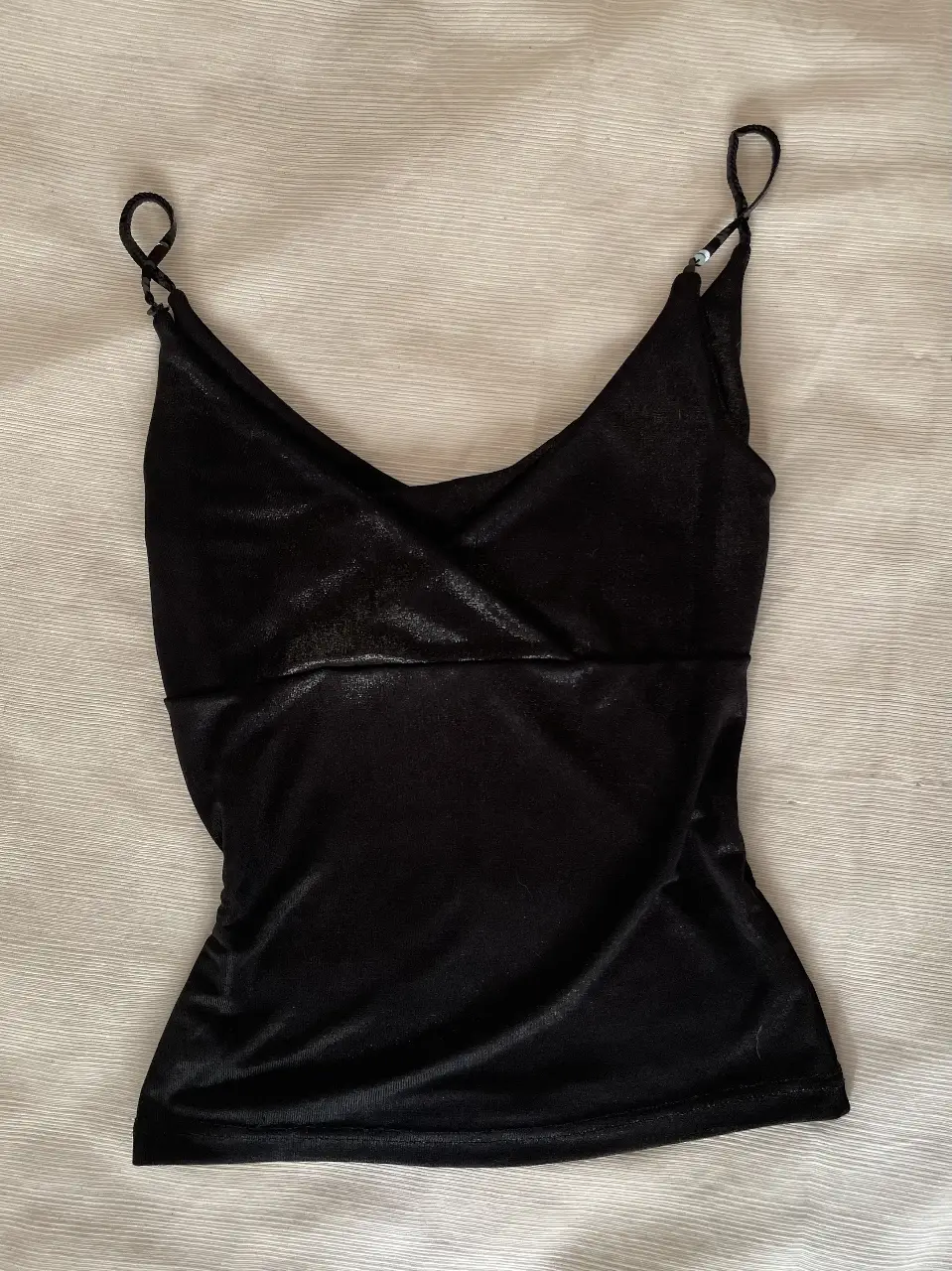 Top negro con breteles finos de lentejuelas y escote en V. Ideal para una salida nocturna o para combinar con un blazer. Va perfecto para un S/M