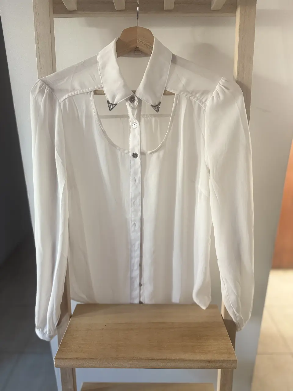 Blusa blanca con detalle de abertura en el cuello y botones. Ideal para un look elegante y sofisticado.