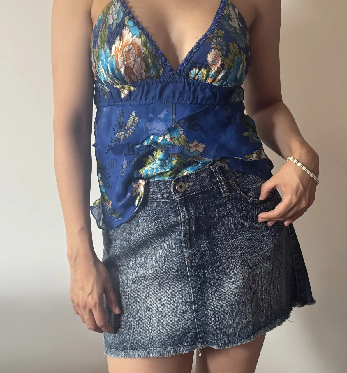 Minifalda de jean azul, con un corte clásico y detalles de desgaste que le dan un toque vintage. Ideal para un look casual y versátil.