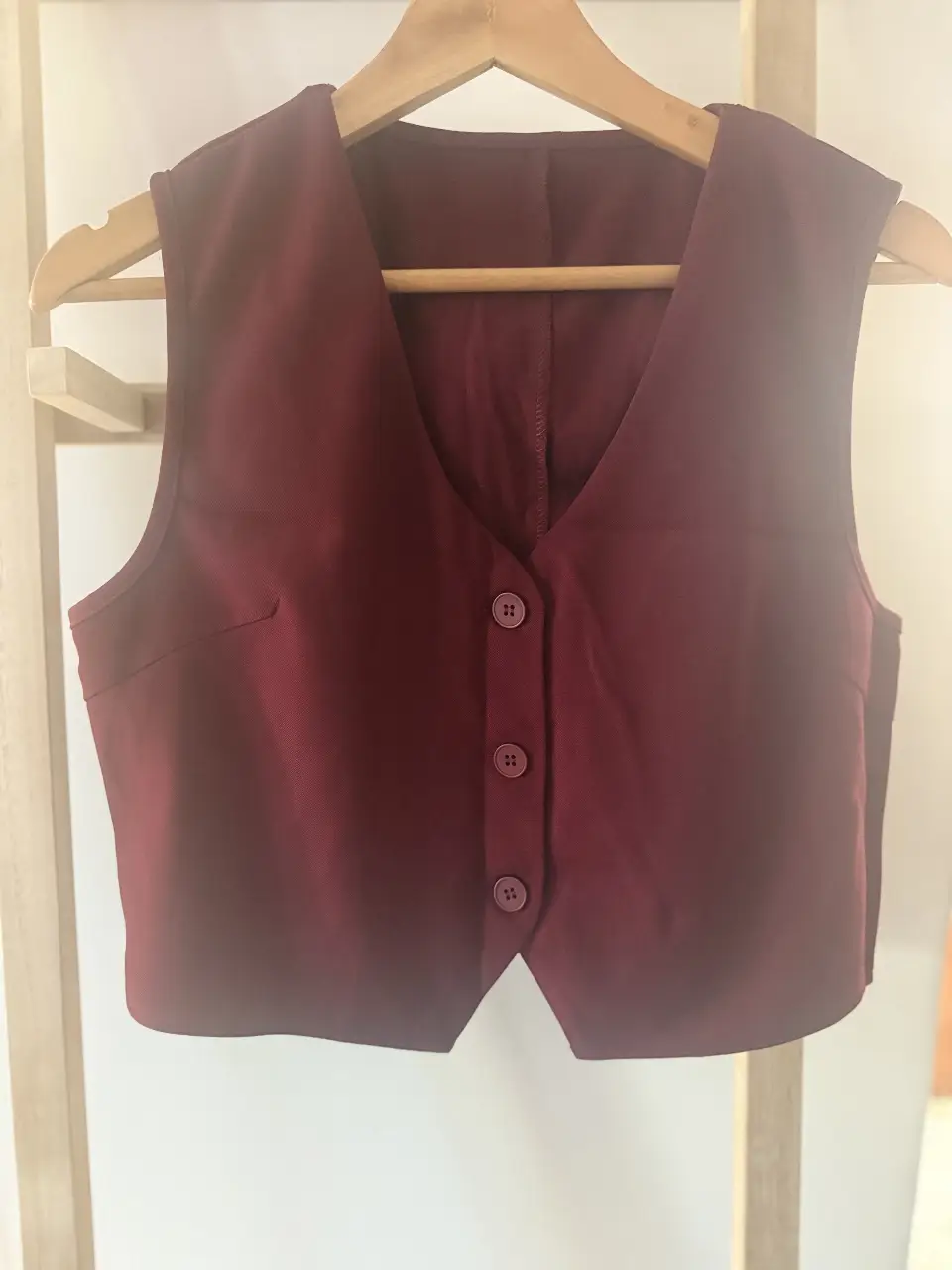 Chaleco sastrero de mujer, color borgoña. Ideal para looks formales o para darle un toque elegante a tu outfit casual. Confeccionado en tela de calidad, este chaleco es una prenda versátil y atemporal.
