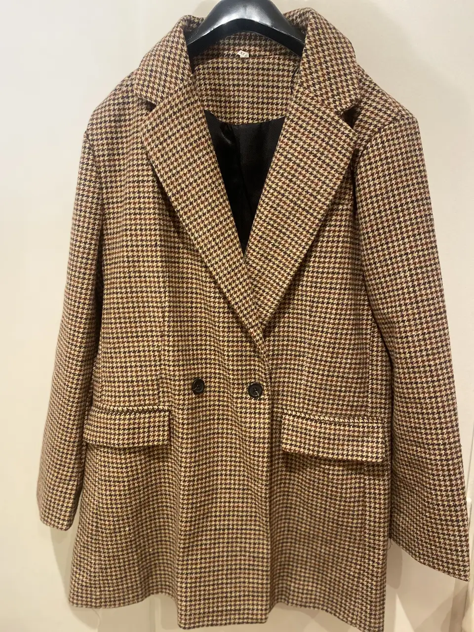 Sobretodo tipo blazer de mujer, con estampado de pata de gallo en tonos marrones y negros. Posee dos bolsillos delanteros, dos botones para cerrar y botones en las mangas. Ideal para un look elegante y sofisticado.