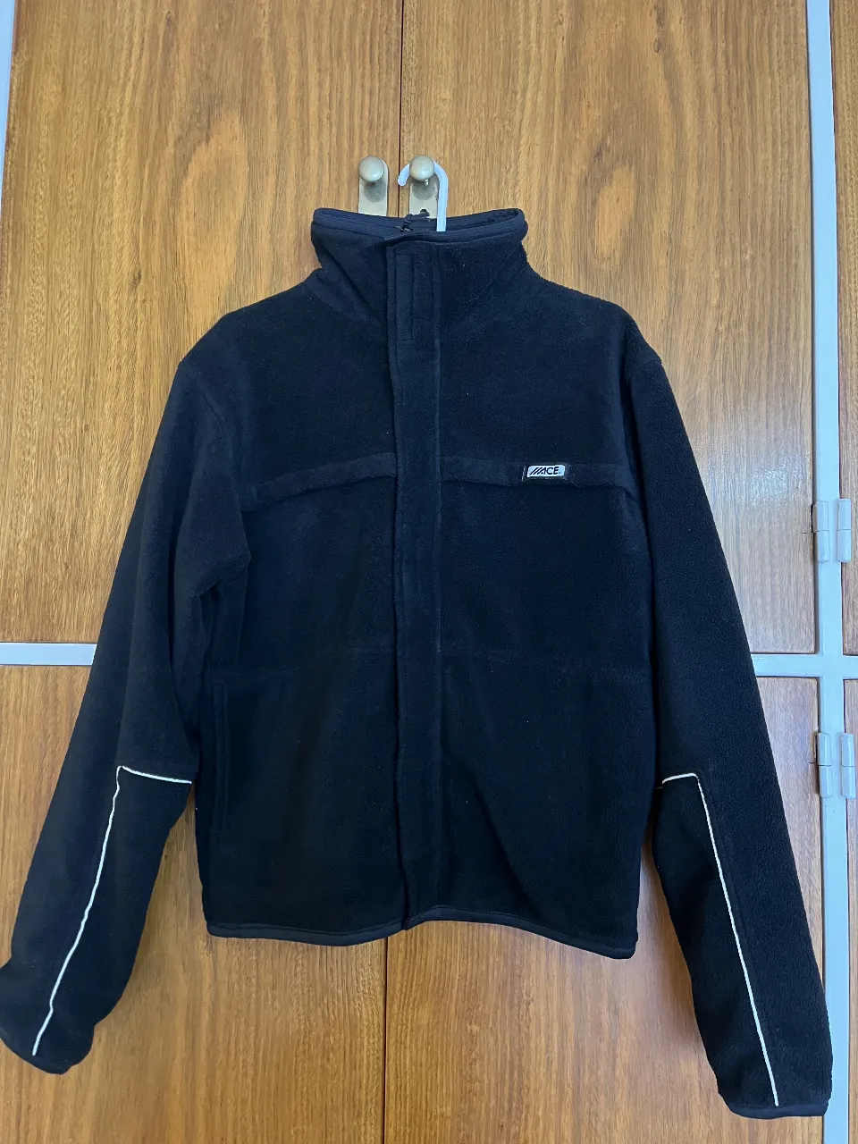 Buzo polar negro con cierre y cuello alto. Interior forrado. Detalles en blanco en mangas. Marca C&A. Talle L.