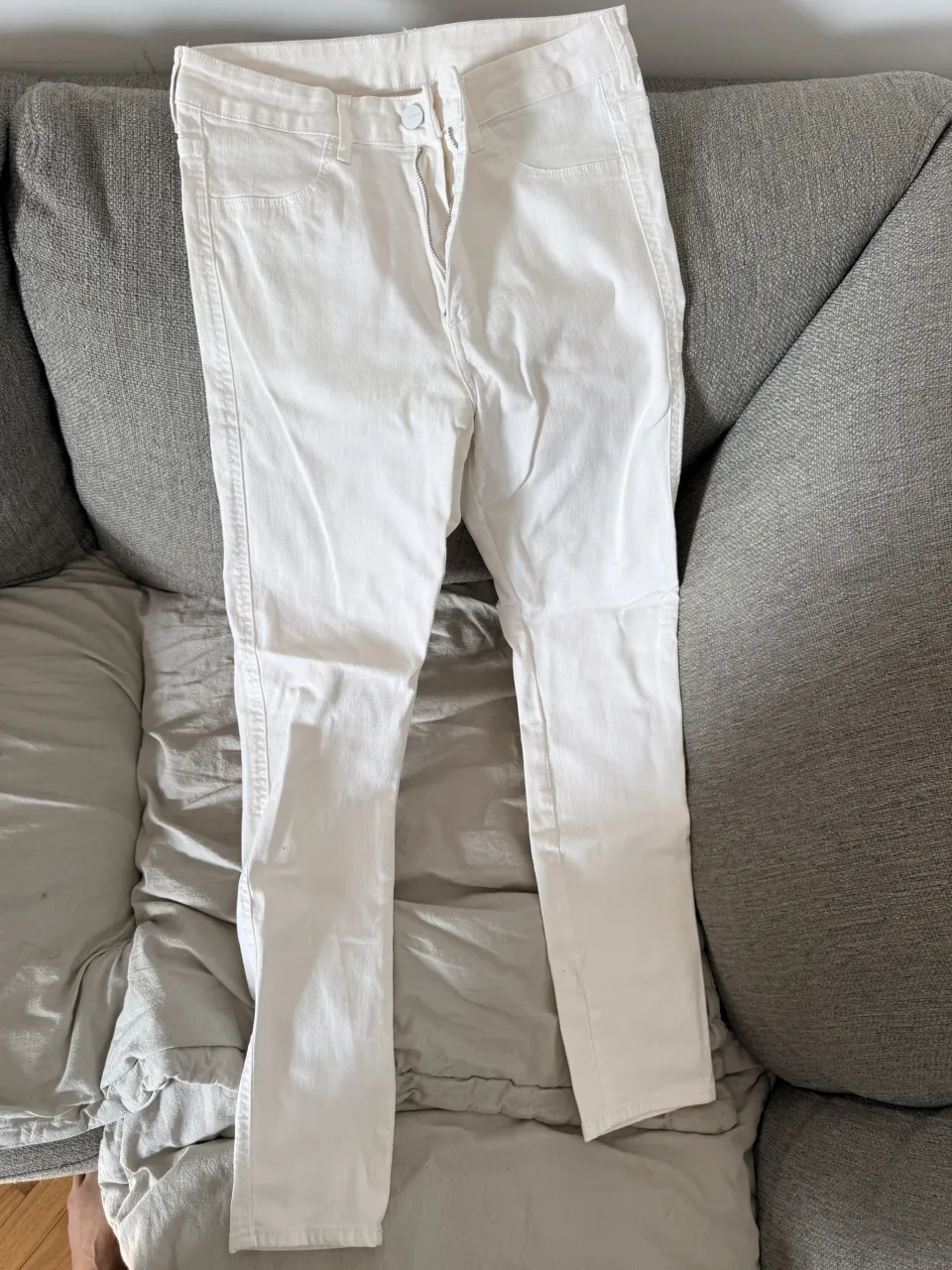 Jeans blancos tiro alto, corte skinny y al tobillo. Perfectos para un look casual y moderno.