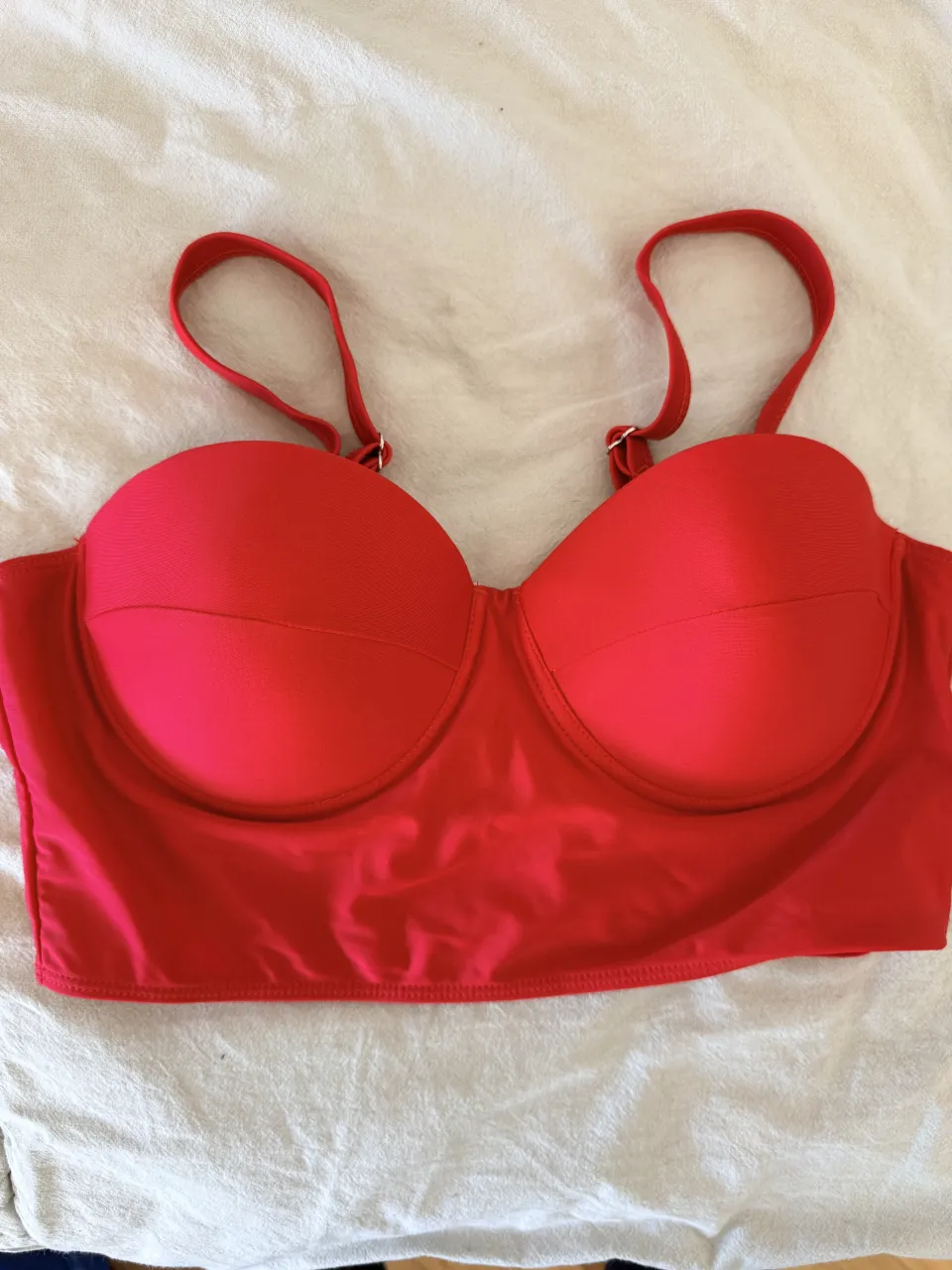 ¡Top de bikini rojo vibrante, ideal para lucir espectacular en la playa o la pileta! Su diseño con aro y copas armadas realza la figura, y sus tiras regulables aseguran un ajuste perfecto. ¡Un must-have para tus días de sol!