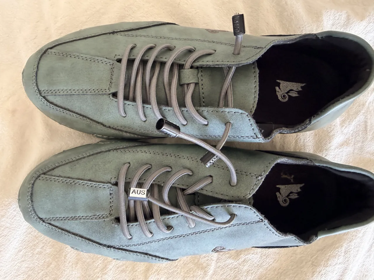 Zapatillas urbanas de cuero color verde agua, con cordones grises y suela clara. Ideales para el día a día, combinan comodidad y estilo.