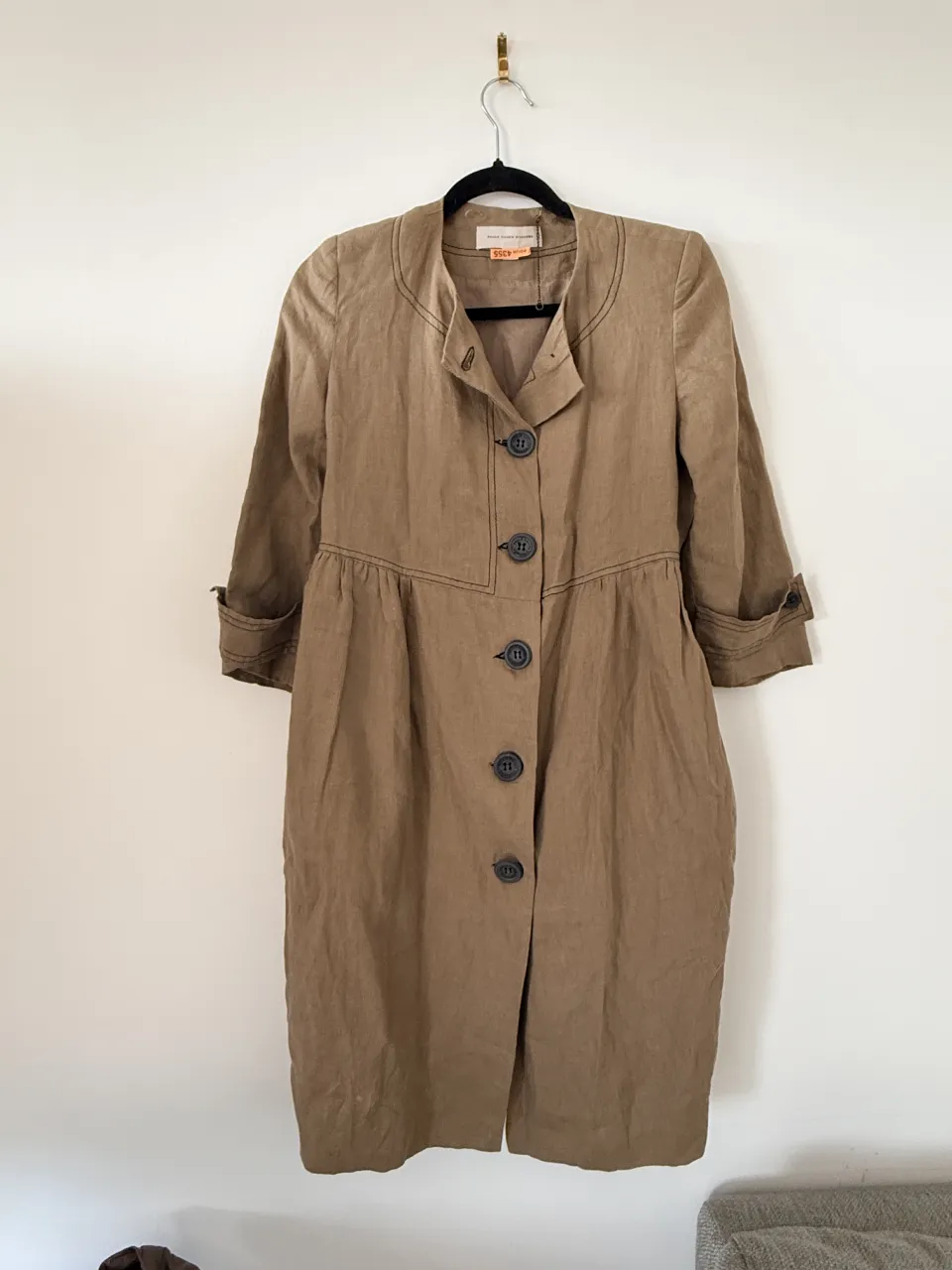 Campera o vestido largo de lino color tiza, con detalles de costura a contratono y botones al frente. Mangas 3/4 con puños doblados. Ideal para un look canchero y moderno.