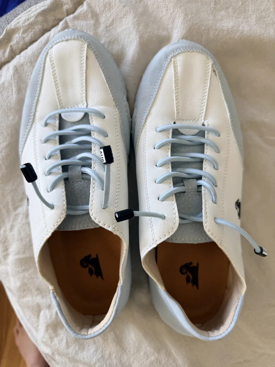 Zapatillas urbanas súper cómodas, ideales para el día a día. Combinan blanco y celeste con un diseño moderno y detalles únicos. Perfectas para un look casual y relajado.
