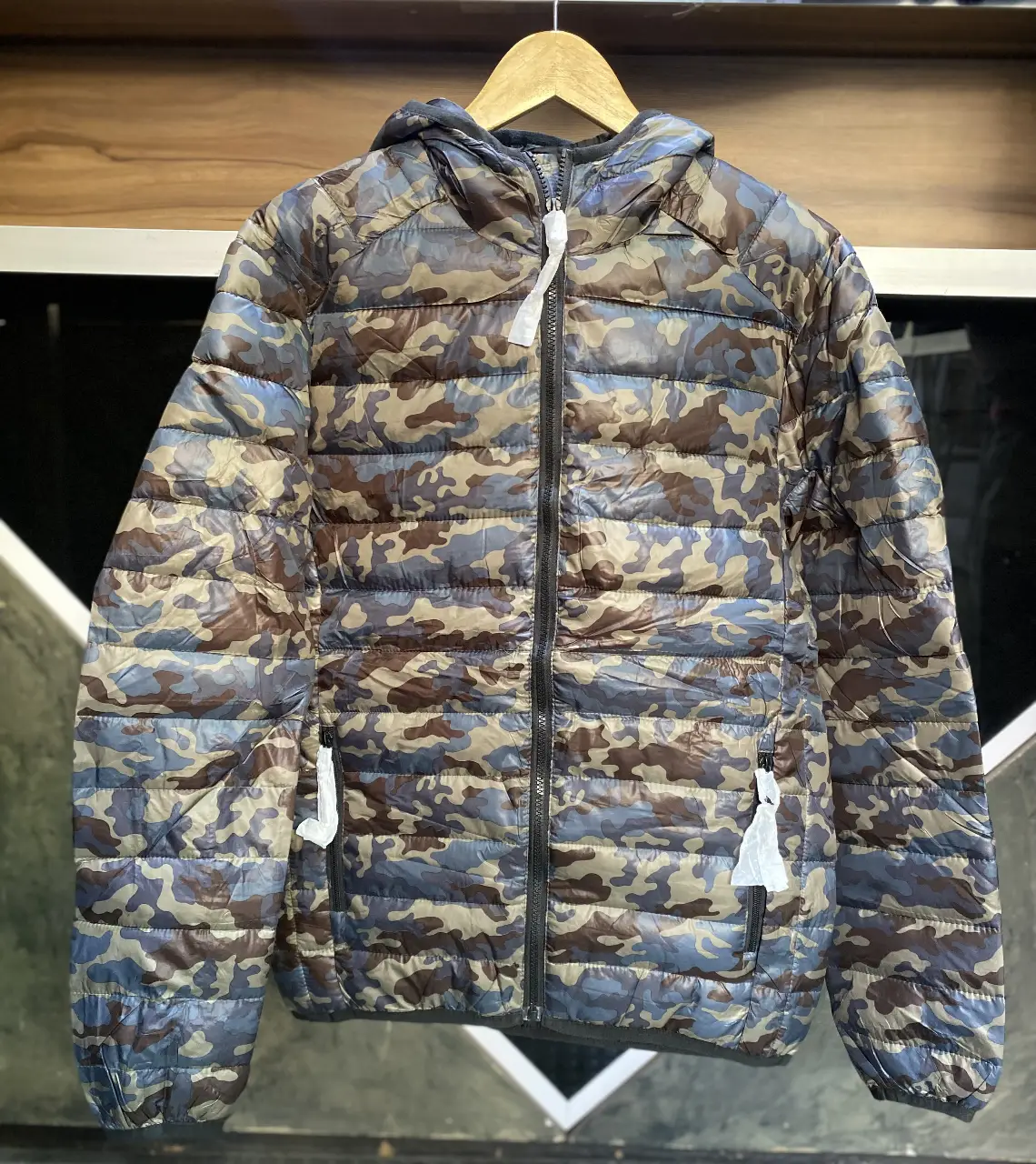 Campera de pluma con estampado camuflado, ideal para el invierno. Cuenta con capucha y cierre frontal. TENGO S,M,L.