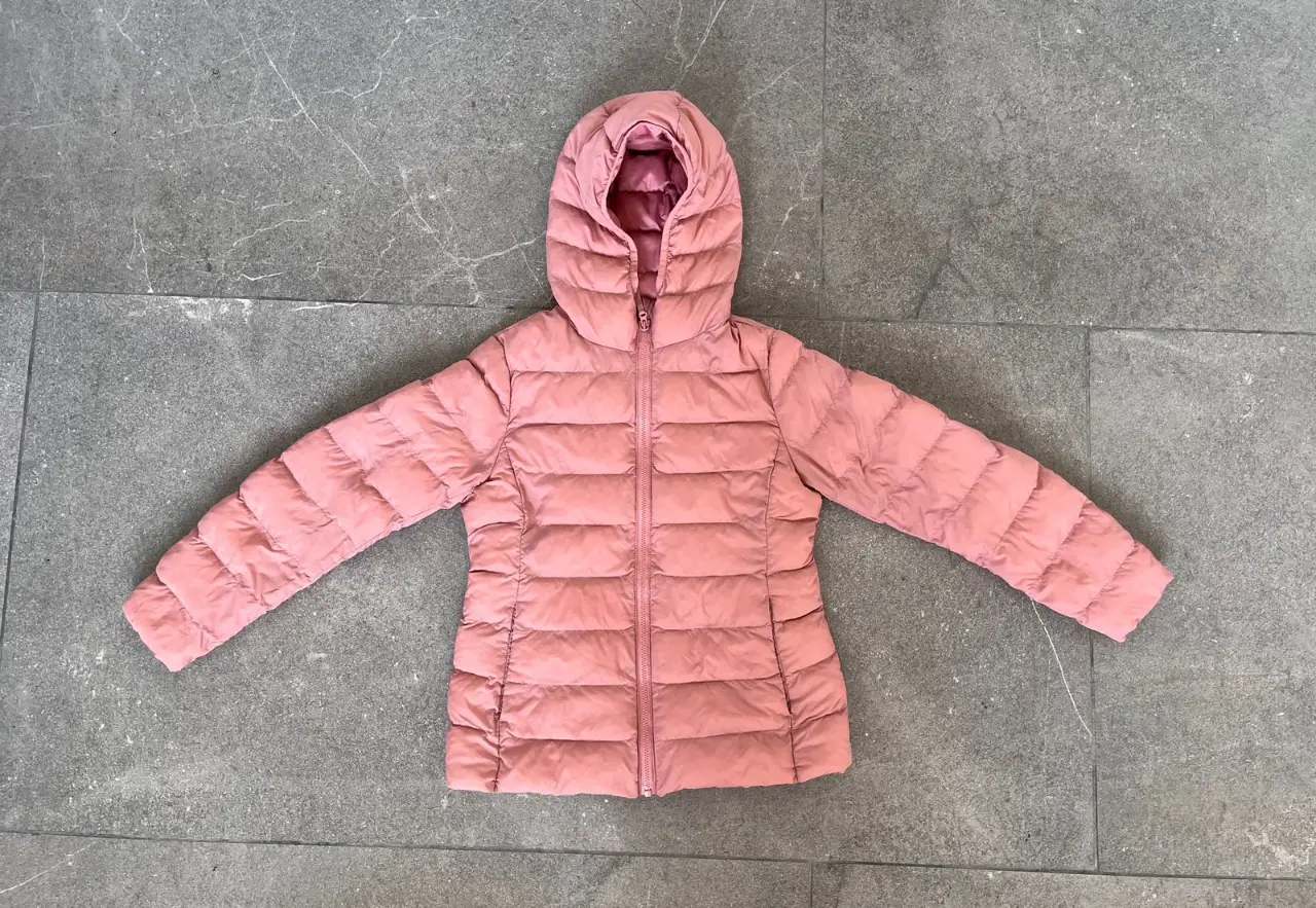 Campera de pluma rosa para niña, ideal para el invierno. Con capucha y cierre frontal, perfecta para mantener a tu hija abrigada y cómoda.