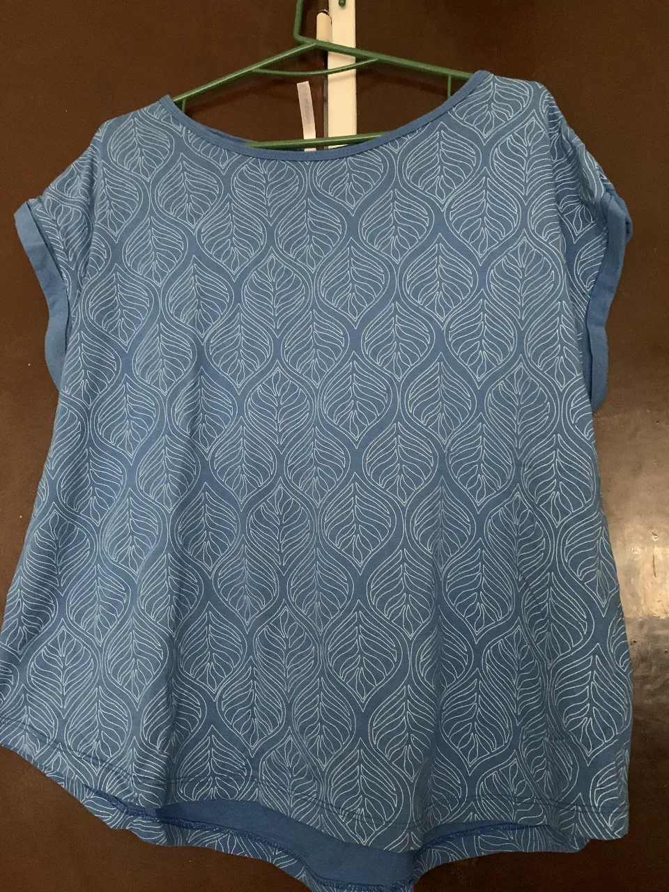 Blusa de mujer con estampado de hojas en tono azul. Diseño con mangas cortas y cuello redondo. Ideal para un look casual y fresco.