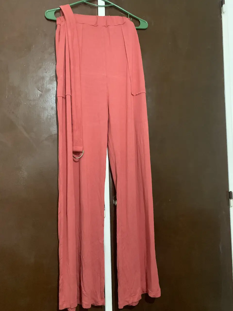 Pantalón suelto de mujer, color rosa, con detalle de cinturón y argolla. Ideal para un look casual y cómodo. 