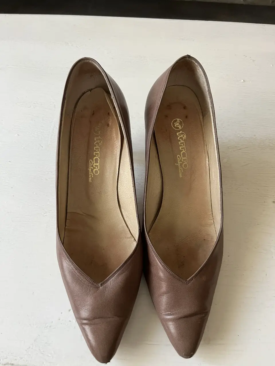 Elegantes zapatos de tacón color marrón, ideales para ocasiones formales. Diseño clásico con punta en V y tacón fino.
