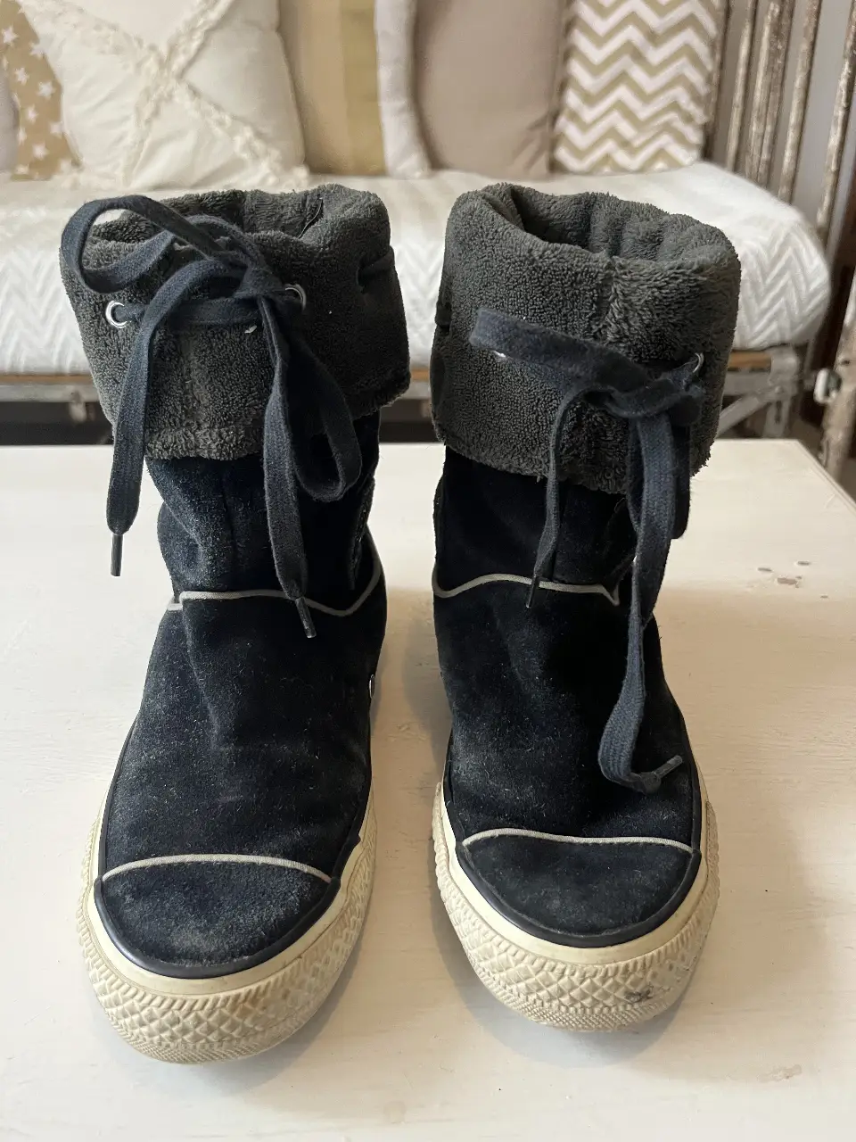 Botas Converse negras de caña alta con detalles en blanco y borde de tela afelpada. Ideales para un look urbano y cómodo.