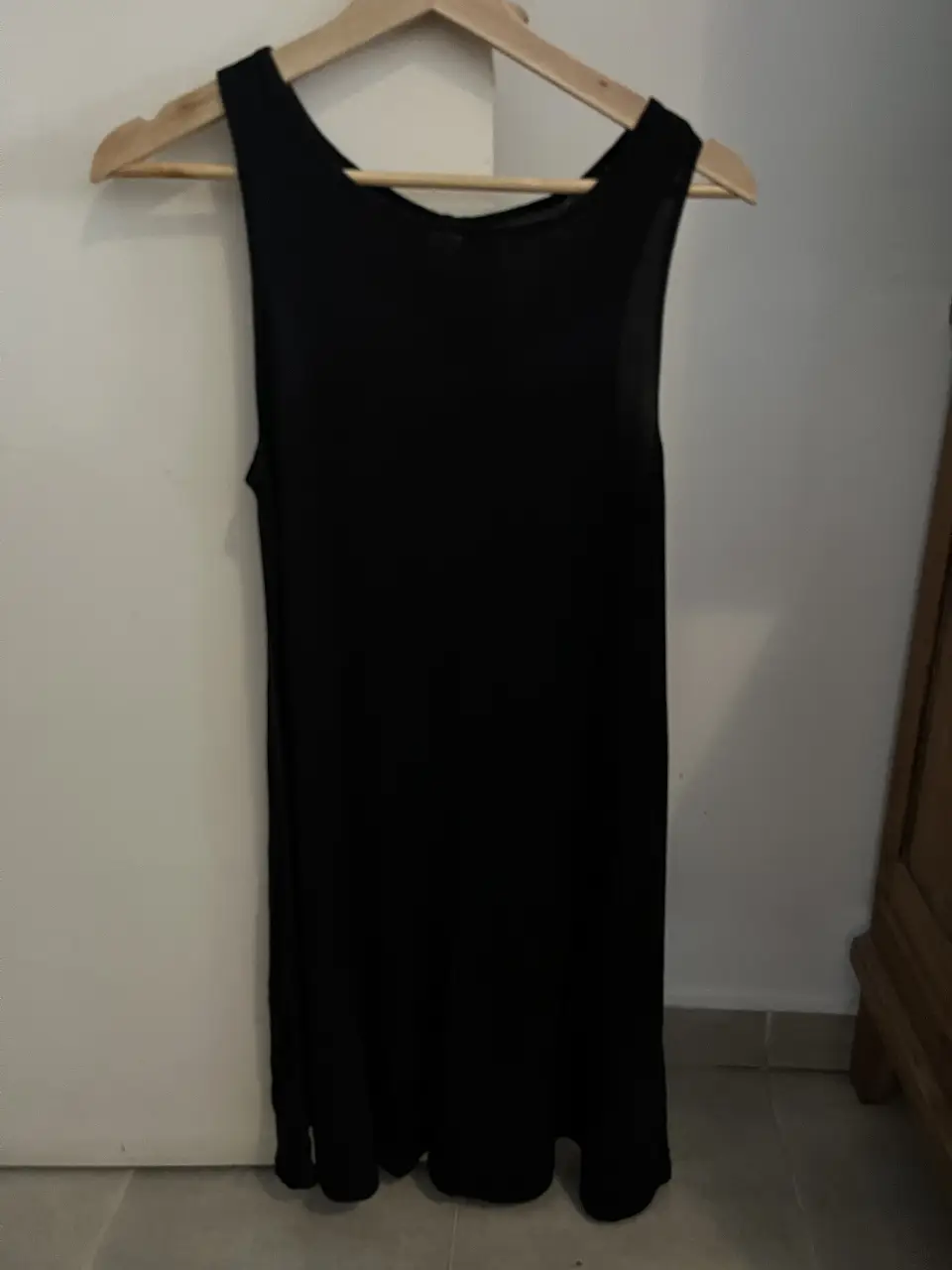 Vestido negro corto, sin mangas, ideal para el verano. Perfecto para una salida casual o para combinar con accesorios y crear un look más elegante.