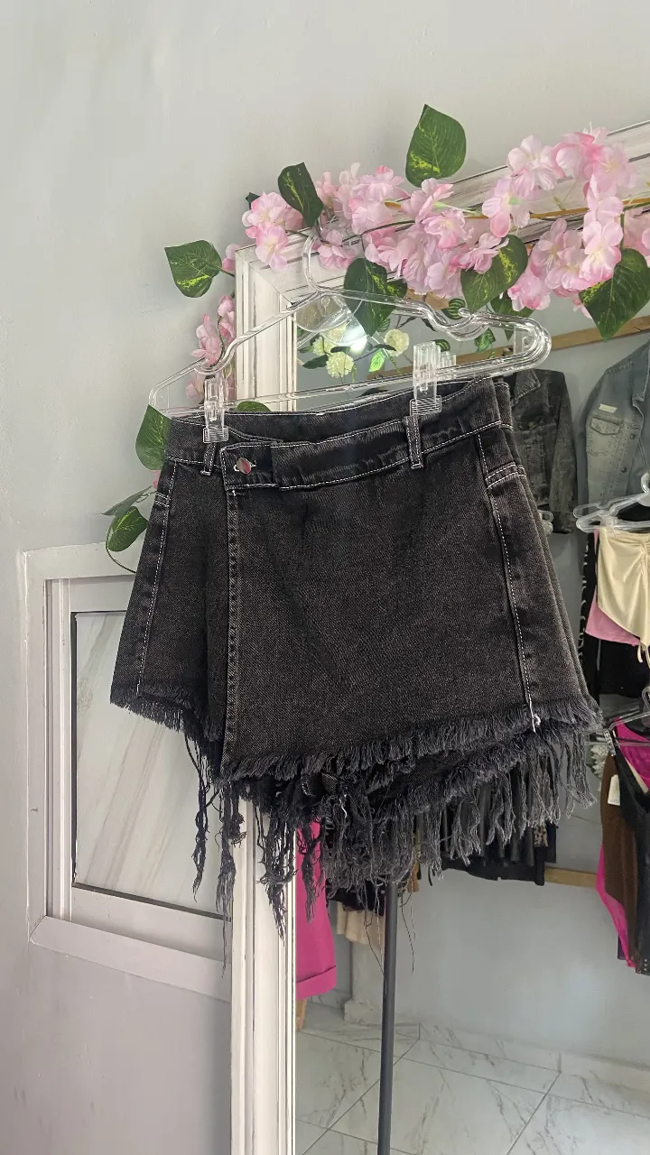 Short de jean negro con flecos en el borde. Es mom. 
Tiro medio, ideal para un look casual y canchero.