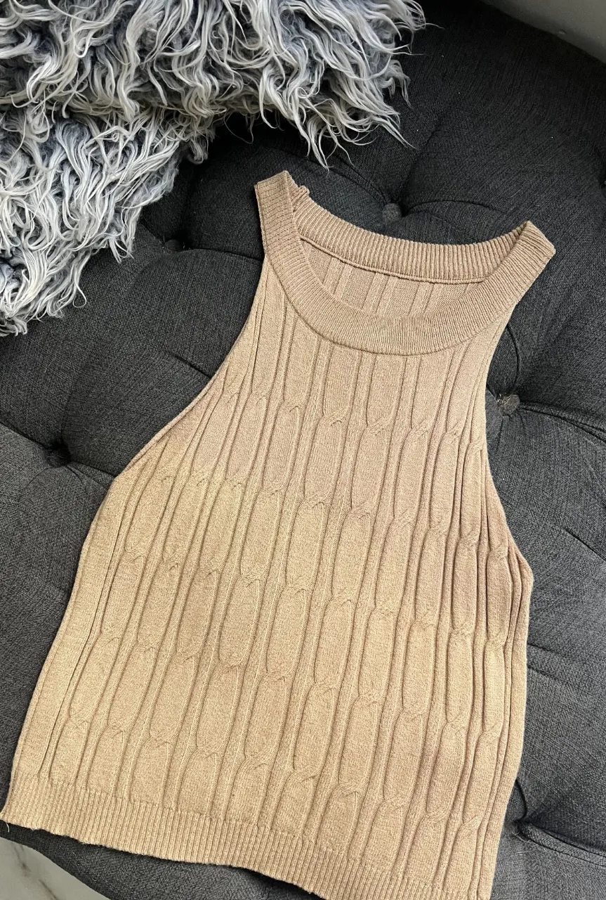Top tejido de punto, sin mangas, con diseño de trenzas. Ideal para un look casual y moderno.