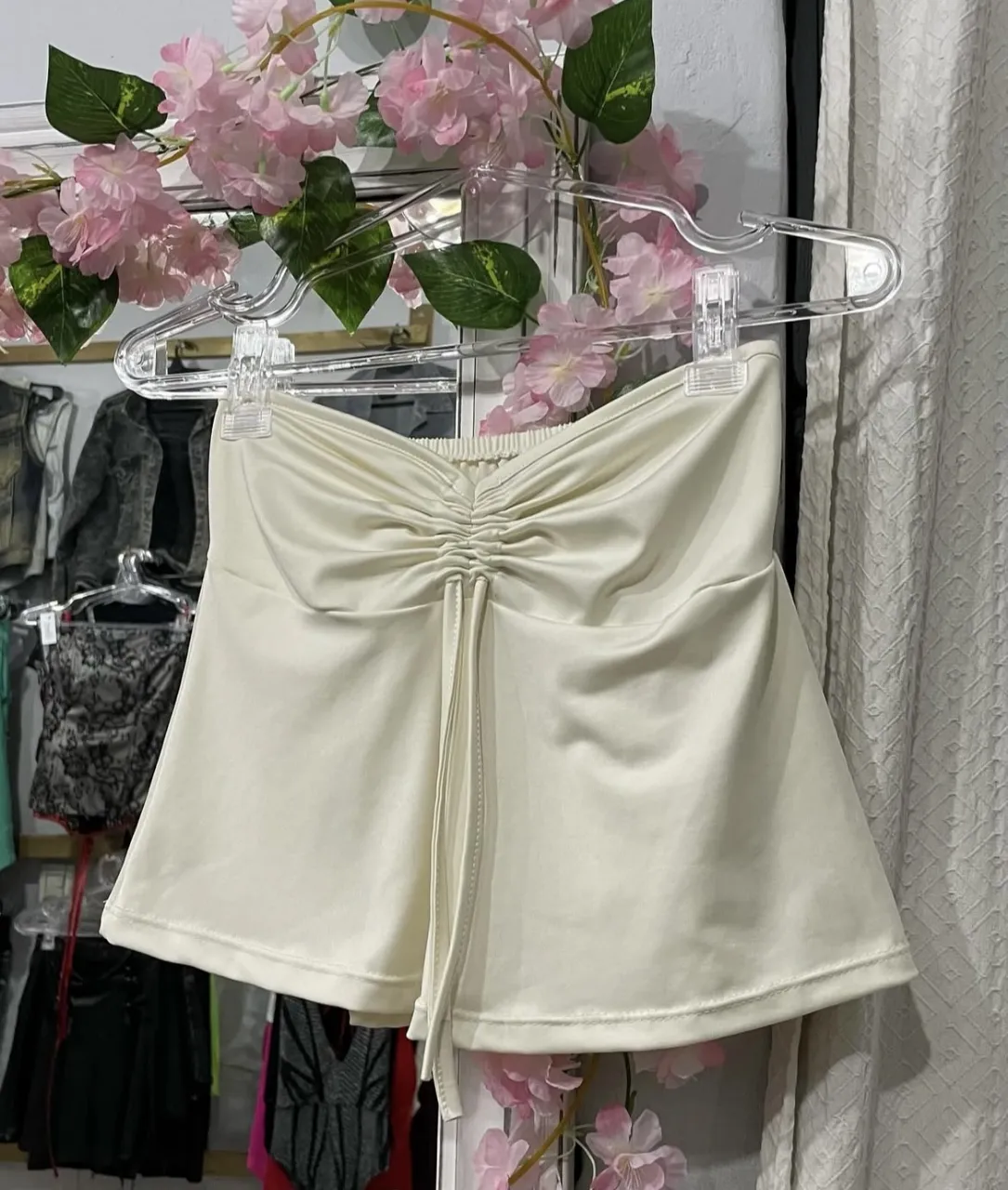 Top blanco con fruncido en el centro y detalle de lazo. Ideal para un look moderno y versátil.