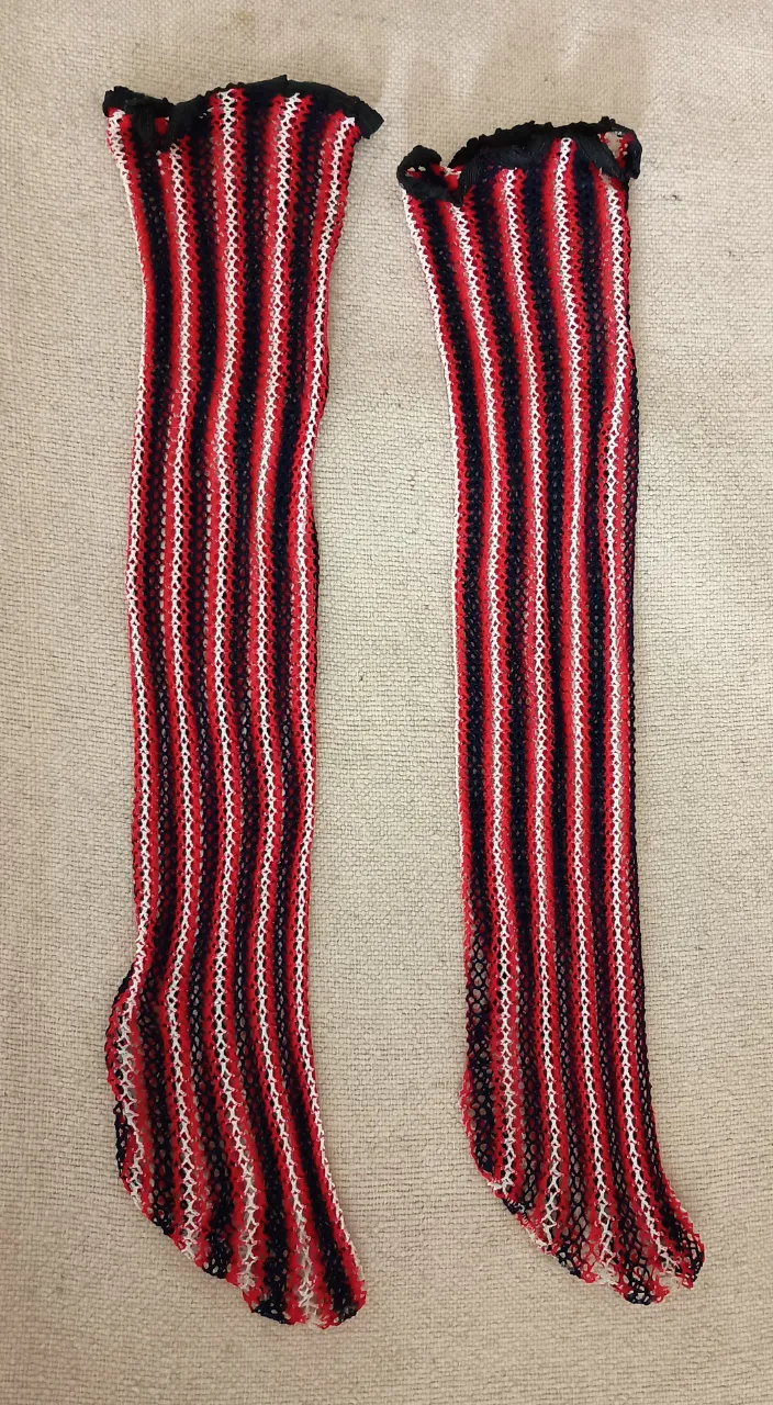 Medias de red bucaneras con diseño a rayas en rojo, blanco y negro. Ideales para complementar looks audaces y modernos.
