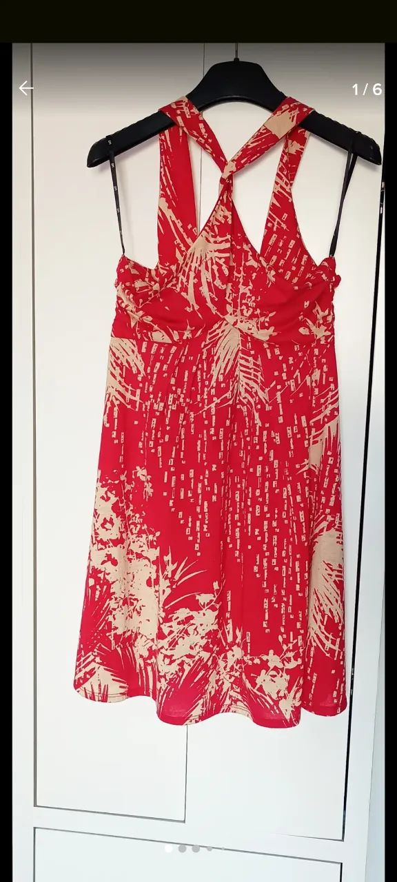 Vestido midi de mujer, con estampado floral en tonos rojos y beige. Diseño con tirantes cruzados en el frente.