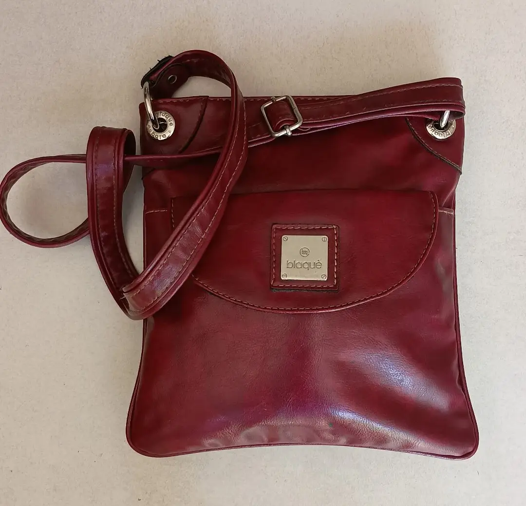 Bandolera roja de cuero sintético, con solapa y cierre de imán. Ideal para llevar tus esenciales con estilo y comodidad. Perfecta para un look casual o para complementar un outfit más arreglado.
