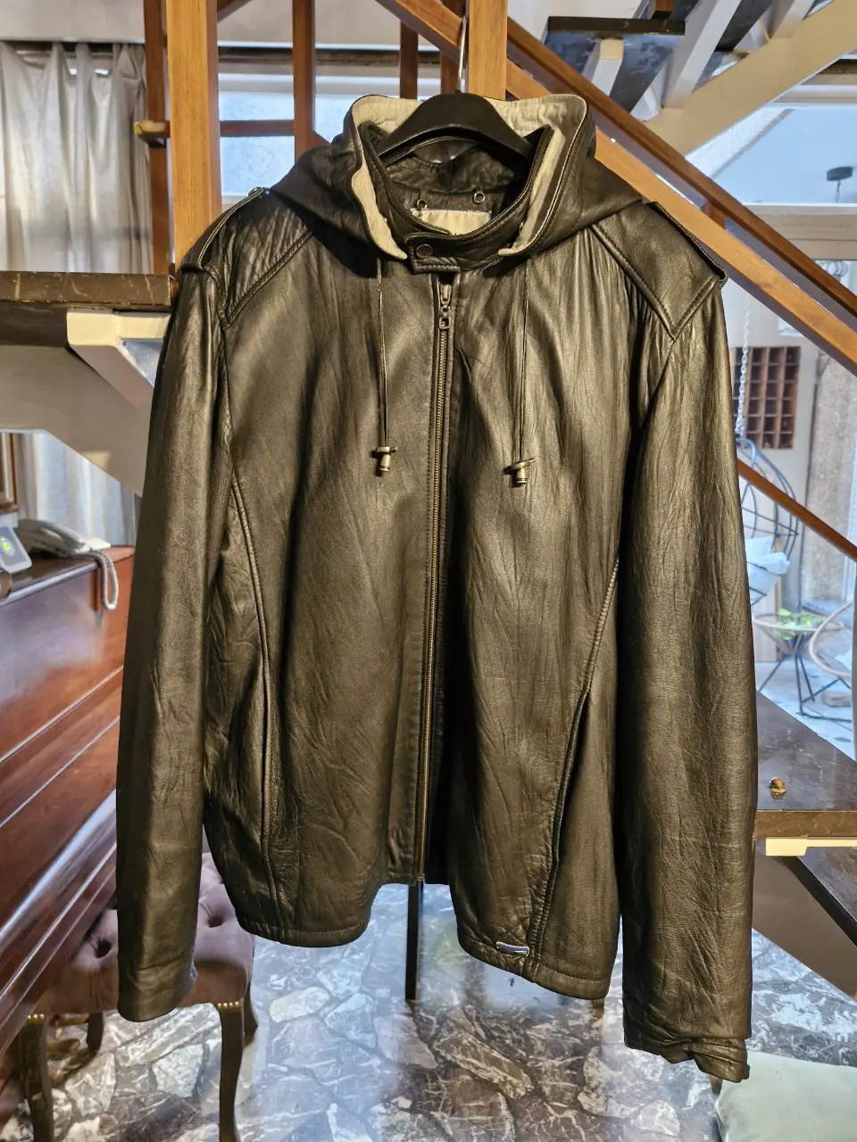 Campera de cuero negra con capucha desmontable, estilo biker, ideal para un look urbano y moderno. Marca Rochas.