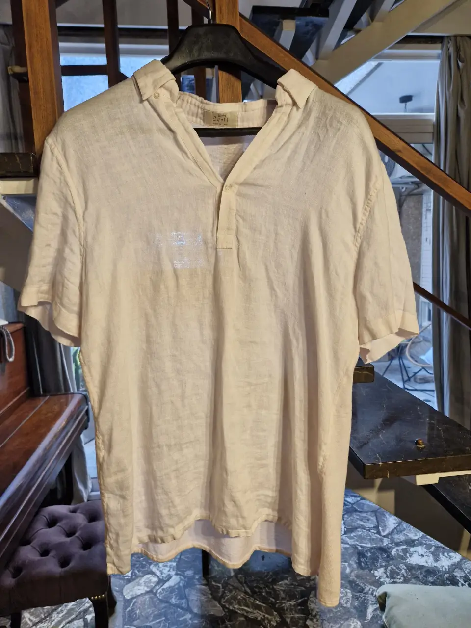 Remera de hombre, manga corta, color crudo, con cuello en V y detalle de botones. Ideal para un look casual y fresco.
