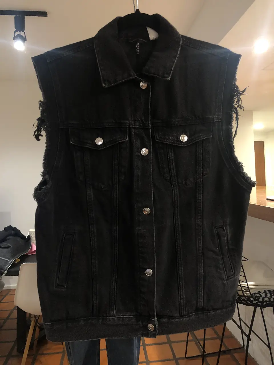 Chaleco de jean negro con detalles desflecados. Ideal para un look casual y canchero. Talle S.