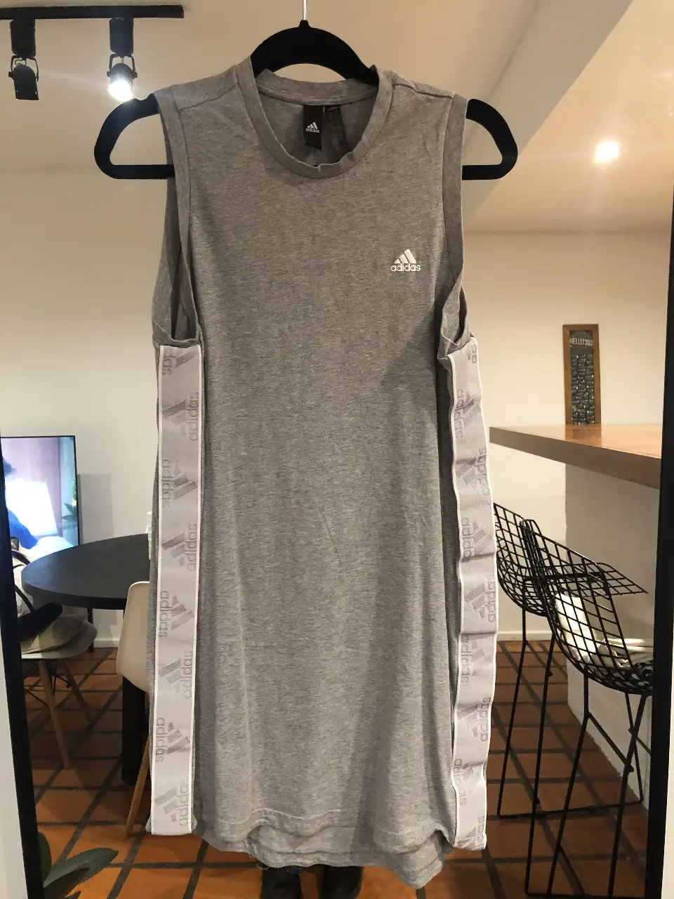 Vestido deportivo Adidas gris con detalles grises en los laterales. Talle M. Ideal para un look casual y cómodo.