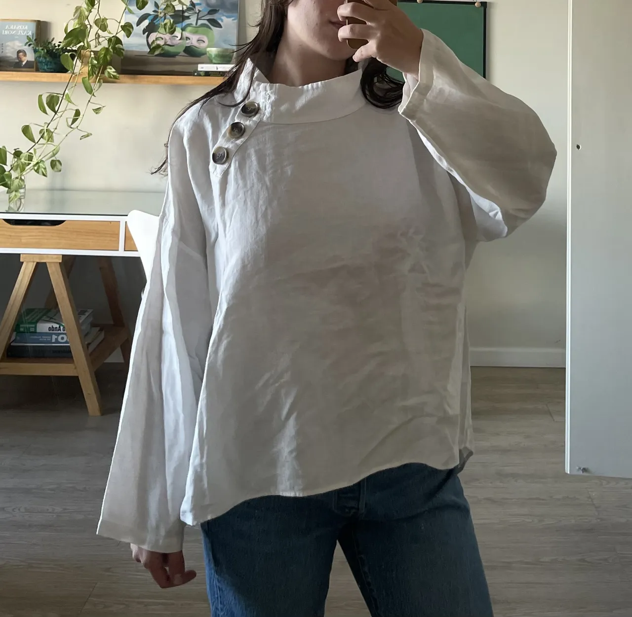 Remera blanca de lino con cuello mao y botones de madera. Manga larga y corte amplio, ideal para un look relajado y chic.