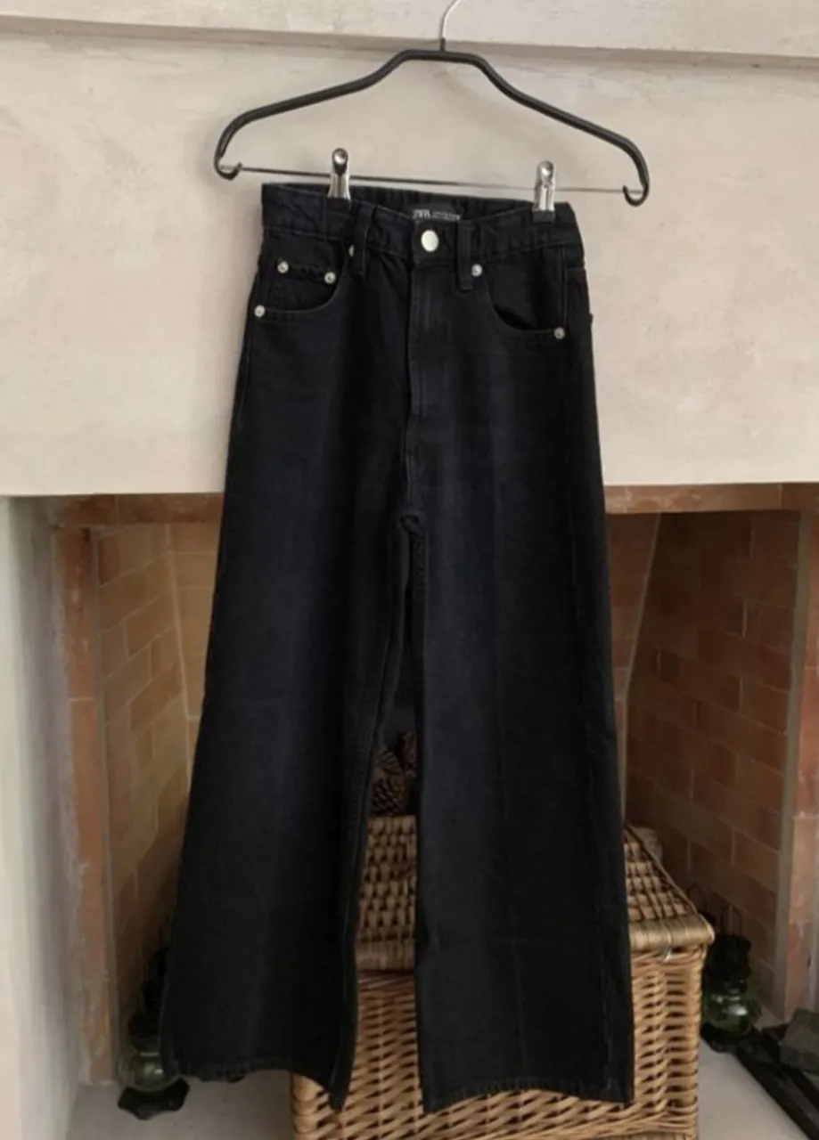 Jean negro con cinco bolsillos y cierre.